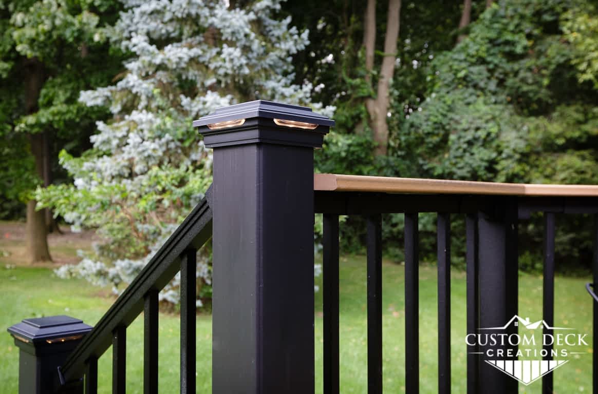 Close up of black composite railing with lights on top of a deck