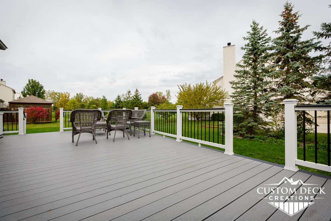 A greenery backyard view from on top of a grey composite deck in Canton Michigan