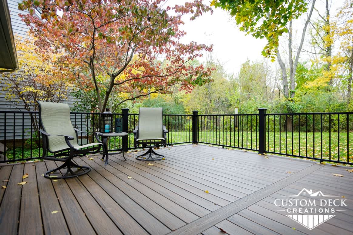 Beautiful Fall photo taken from a backyard deck shown with two lounge patio chairs