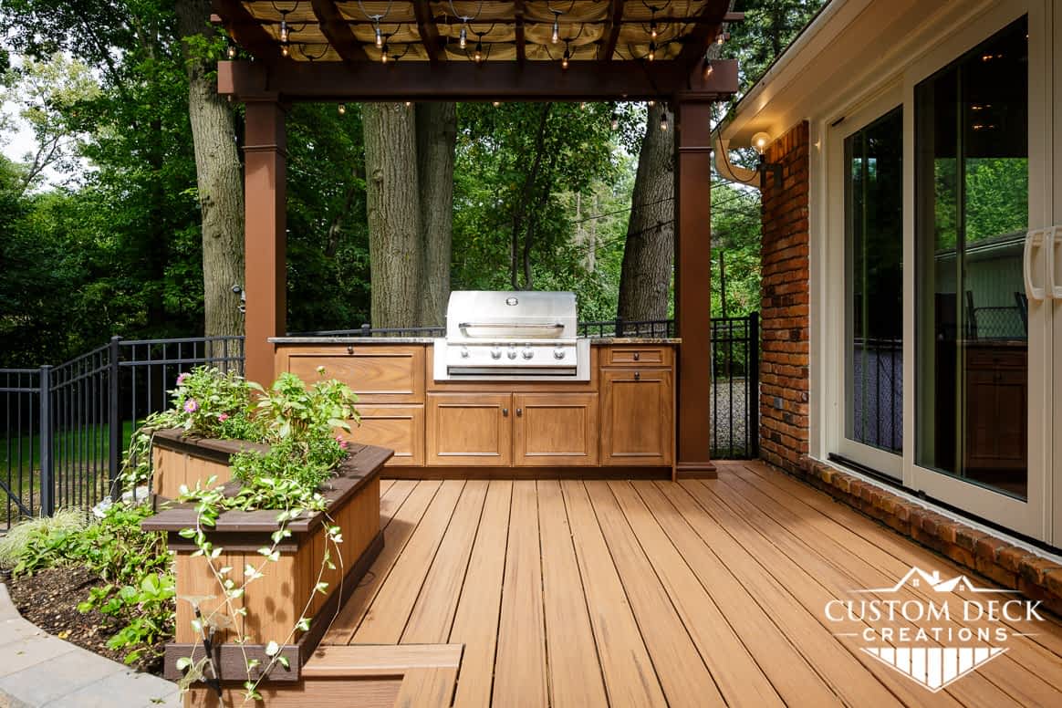 Outdoor kitchen with granite and built in grill with pergola and lights above it