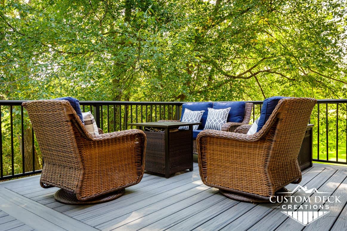 Chairs and a fire pit on top of a grey composite backyard deck