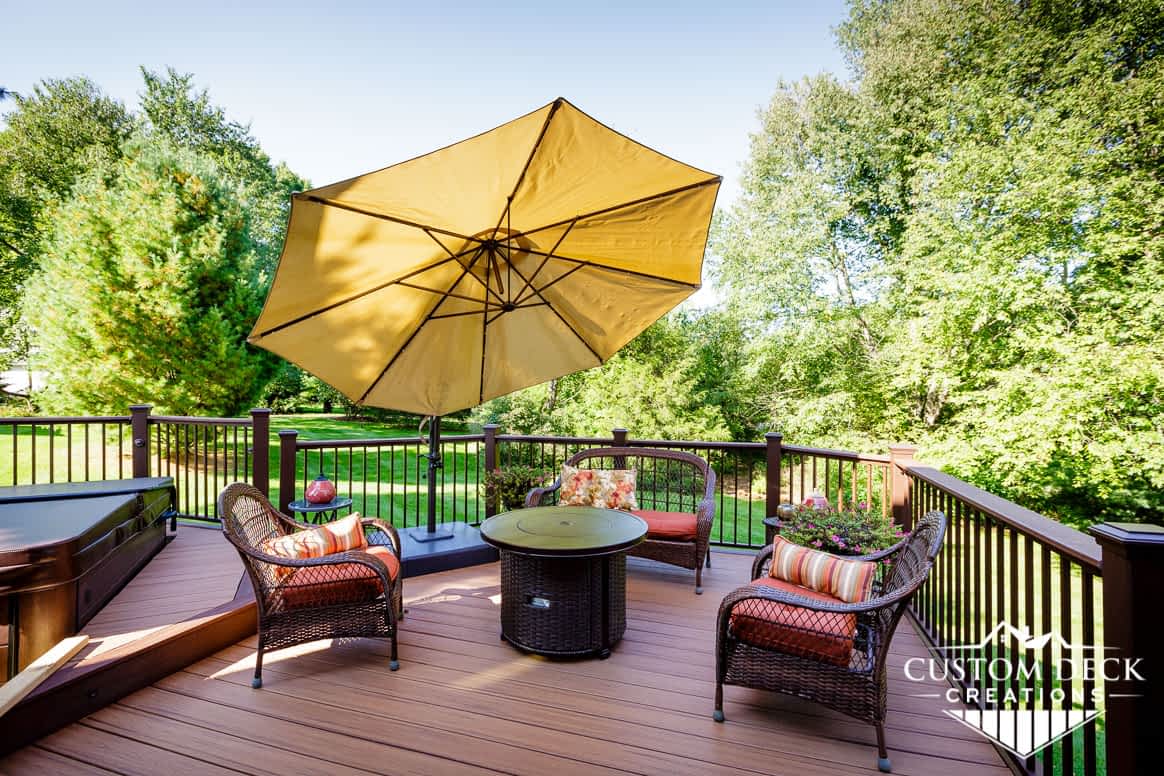 Beautiful shaded view of greenery backyard on top of a brown composite deck