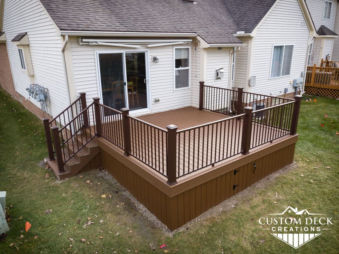 Deck on the back of a condo with stairs and an underside access panel door