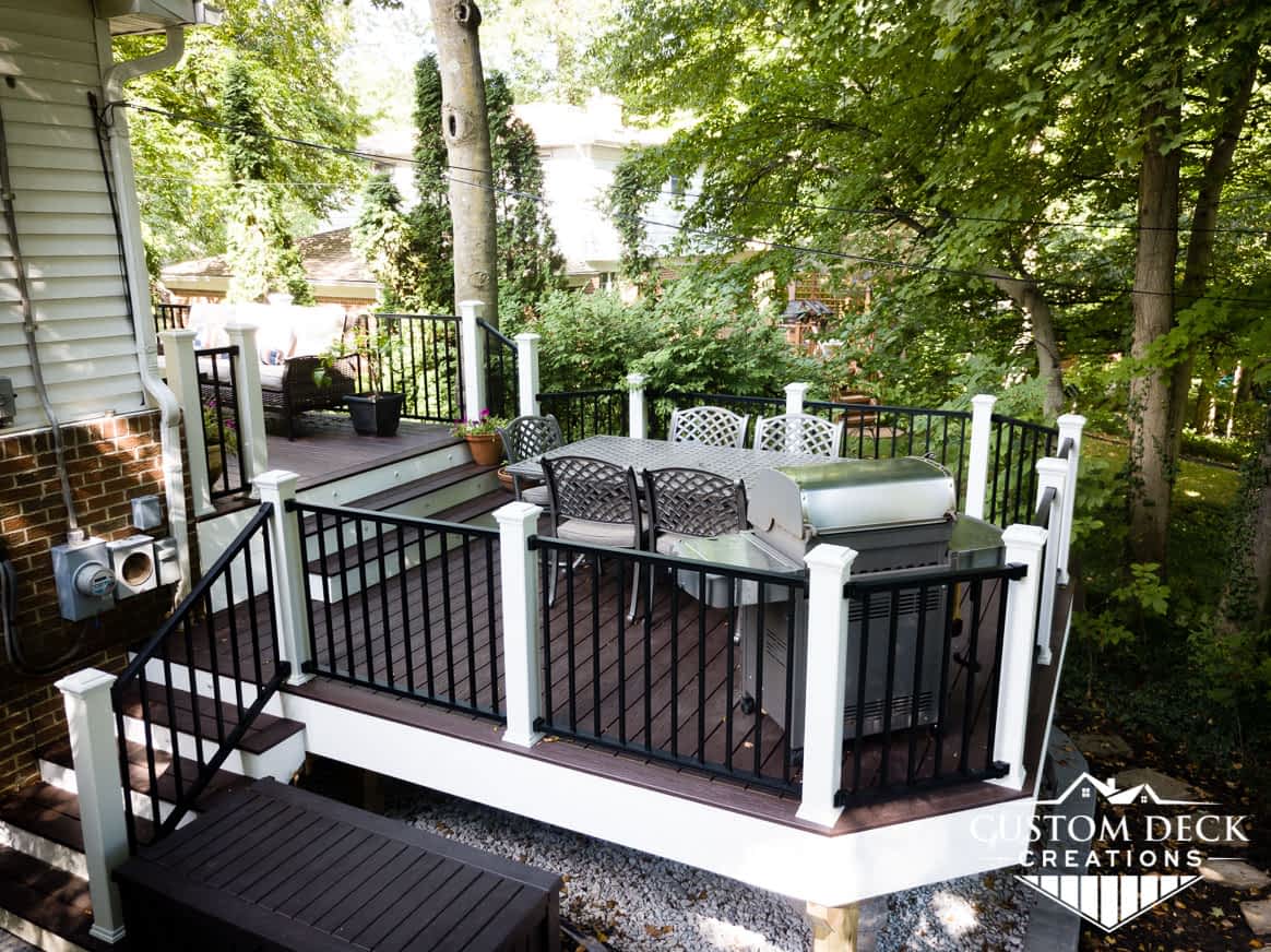 Brown and white deck with multiple sets of stairs off the back of a home in Northville Michigan