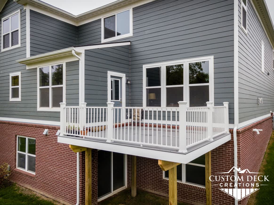 2nd story grey deck without stairs with all white railing off a Canton Michigan new construction home