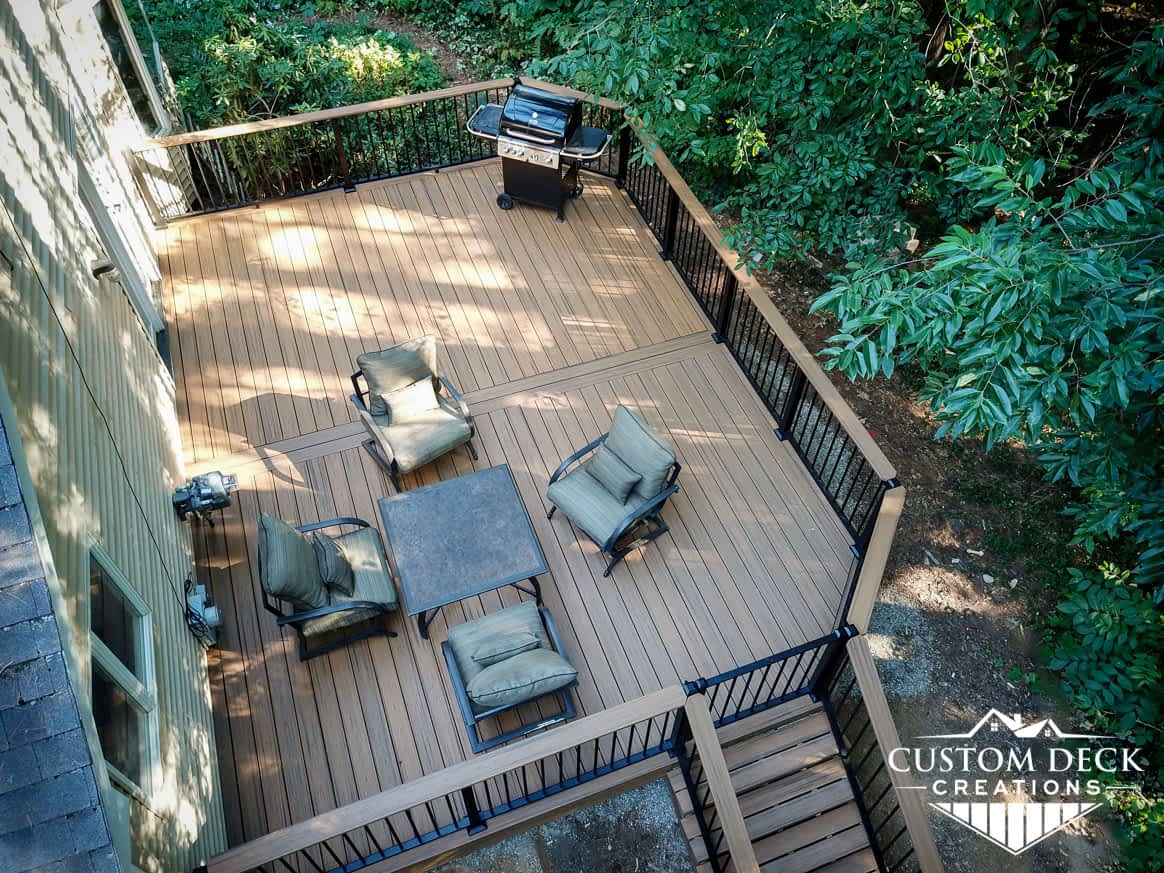 Home with composite deck, seating area with table and chairs, and a grill