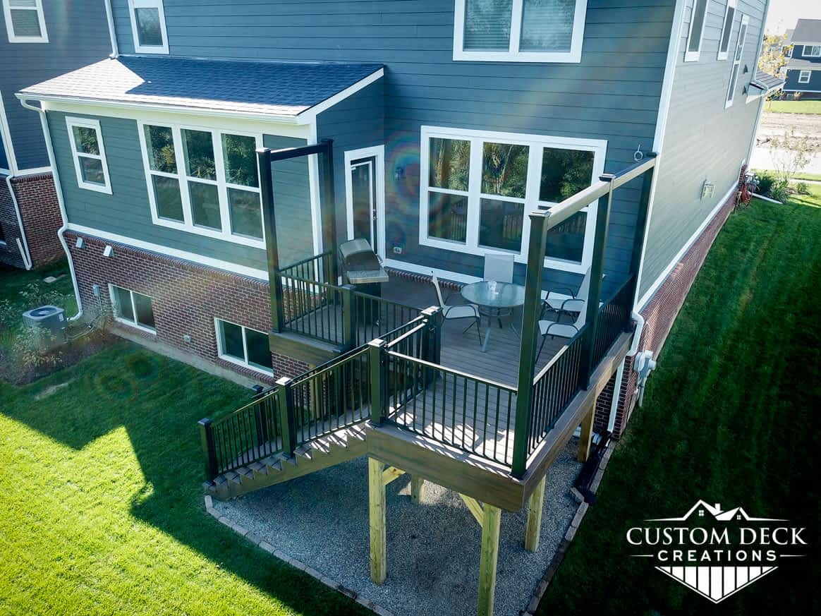 Aerial view of a brown and black backyard 2nd story deck with built in privacy railings
