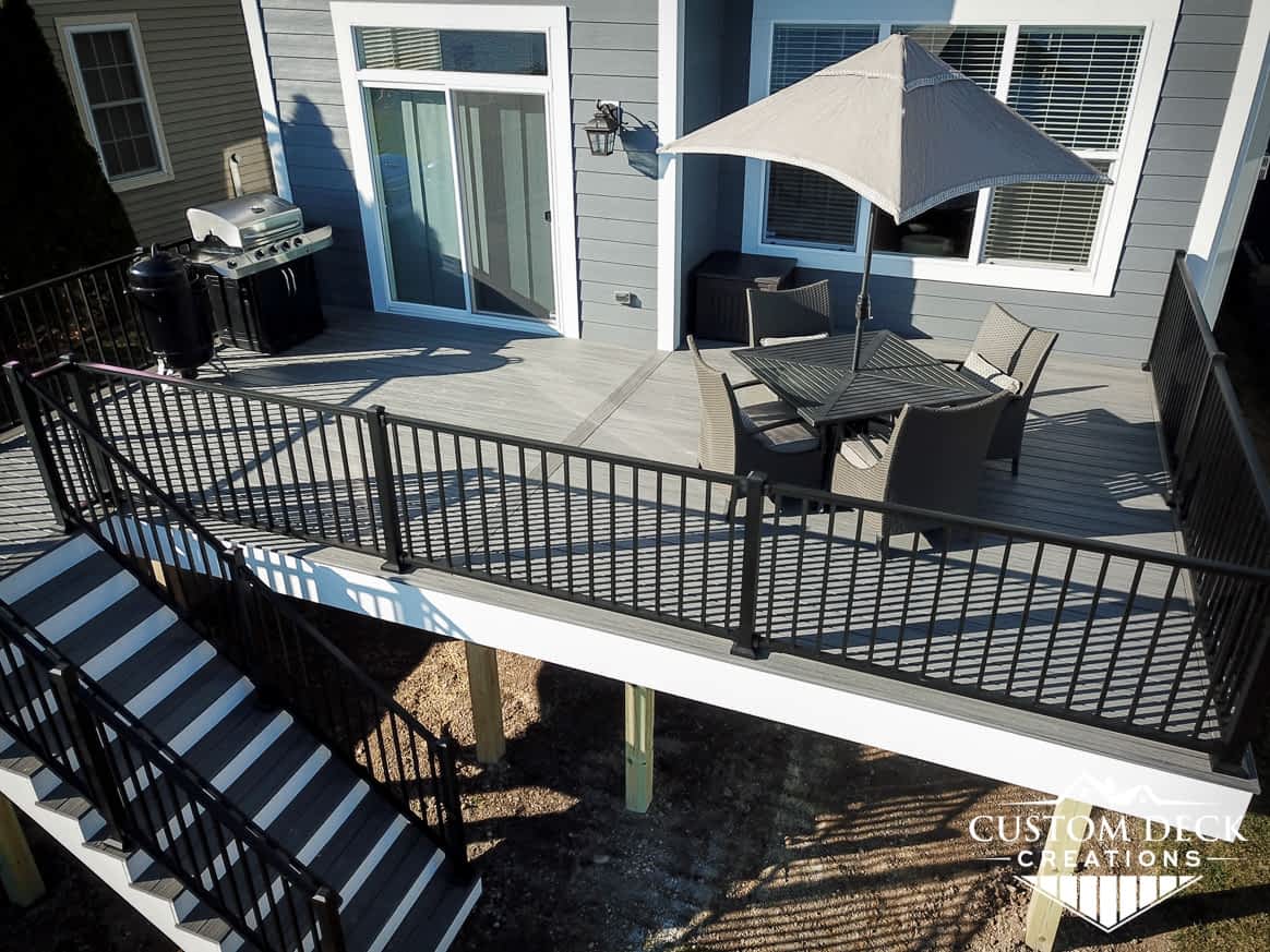 Aerial view of a backyard deck with patio furniture and grill