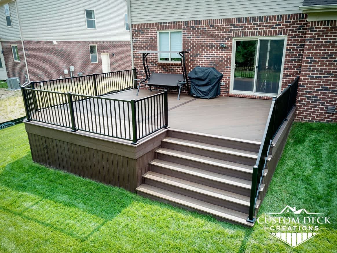 Composite deck with stairs and railing leading to backyard