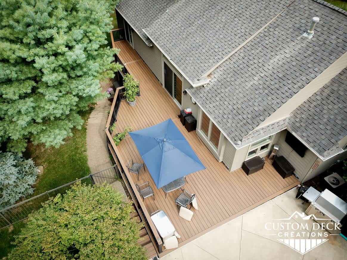 Aerial view of a backyard composite Trex deck with drink rail