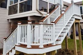 Composite stairs in Trex Tree House and white colors built onto the back of a sunroom