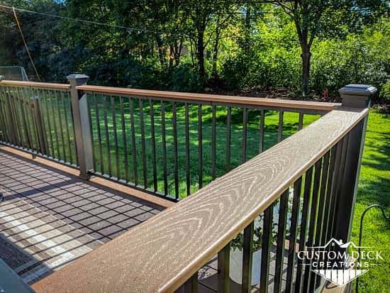 Flat decking board on the railing of a backyard deck